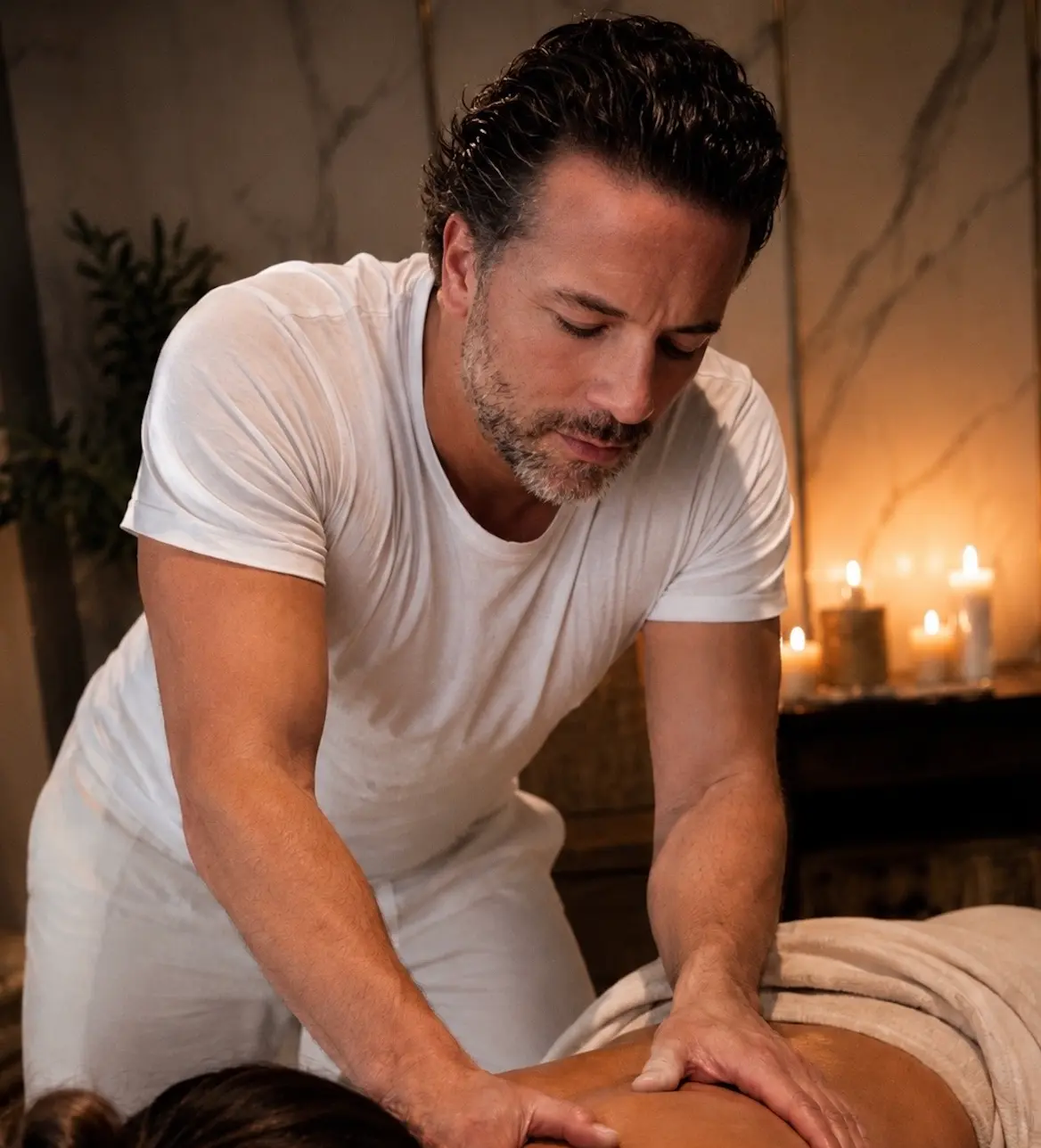 Vince providing a focused massage in a warm, candlelit setting